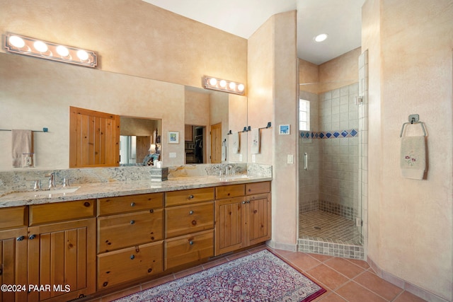 bathroom featuring tile patterned floors, vanity, and a shower with shower door