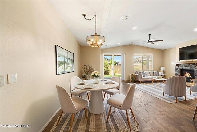 1364 Towhee Trl, Prescott, AZ 86305 - dining room featuring vaulted ceiling, wood finished floors, a chandelier, baseboards, and a stone fireplace