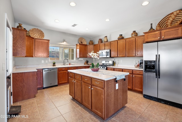 kitchen with a center island, light tile patterned floors, stainless steel appliances, and sink