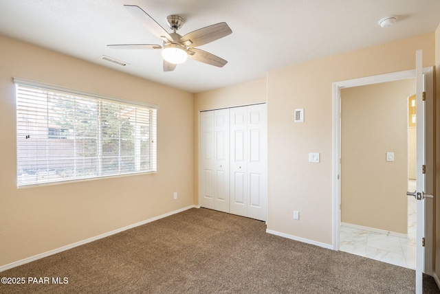 unfurnished bedroom with carpet, visible vents, a closet, and baseboards