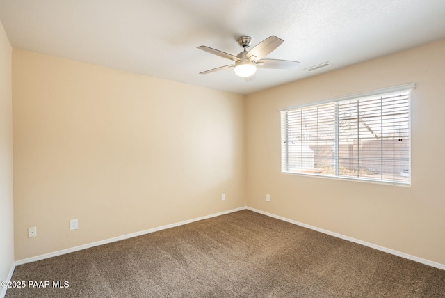 carpeted empty room with a ceiling fan, visible vents, and baseboards