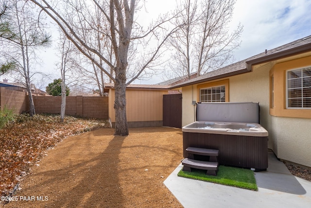 view of yard with fence and a hot tub