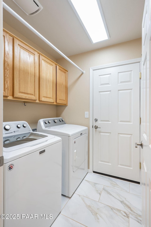 laundry area featuring cabinet space, marble finish floor, and washer and clothes dryer