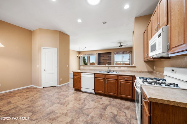 7876 N Siesta Sunset Ln, Prescott Valley, AZ 86315 - kitchen with brown cabinets, a sink, baseboards, light countertops, and white appliances