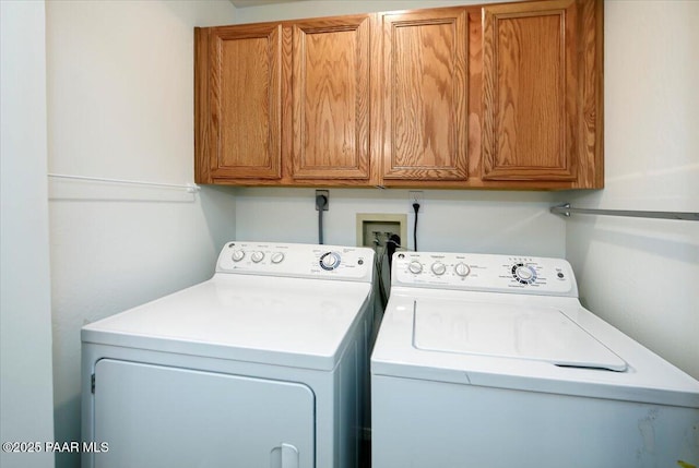 clothes washing area featuring cabinet space and washing machine and clothes dryer