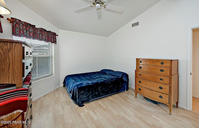 bedroom featuring visible vents, baseboards, lofted ceiling, wood finished floors, and a ceiling fan