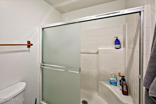 full bath featuring toilet and a tile shower