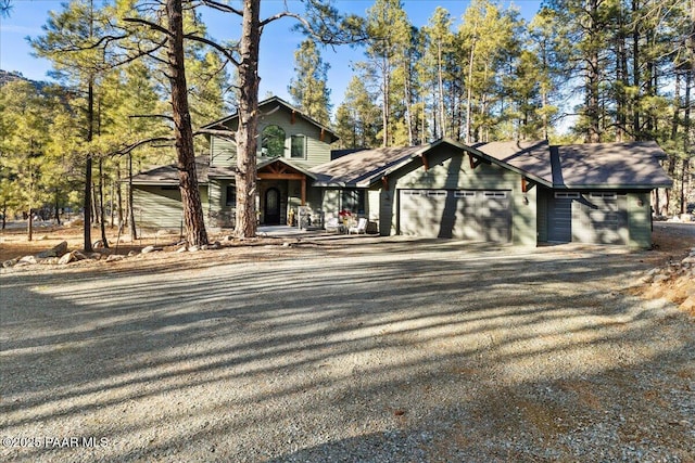 chalet / cabin featuring gravel driveway and a garage