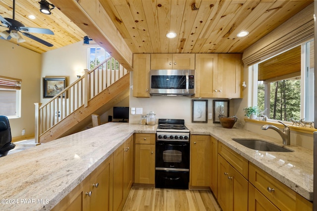 kitchen with a sink, stainless steel microwave, light stone counters, wooden ceiling, and black range oven
