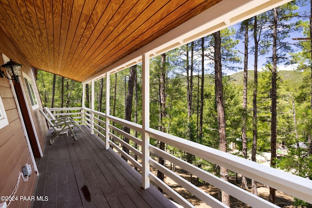 wooden deck with a wooded view