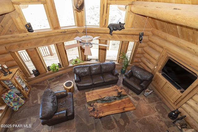 living room featuring ceiling fan, log walls, and a towering ceiling