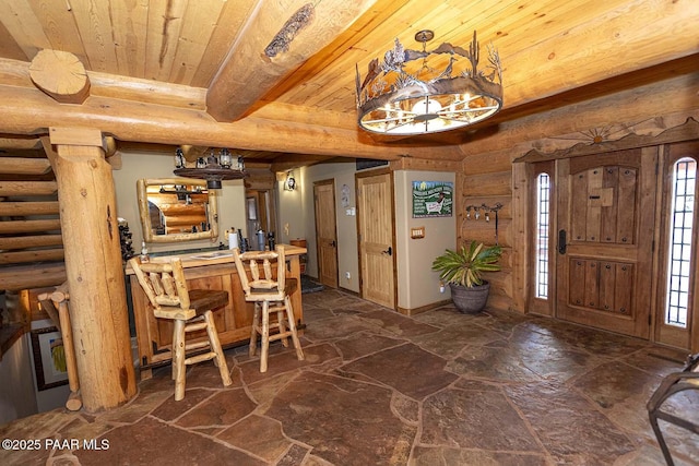 foyer with wooden ceiling, indoor bar, log walls, and beamed ceiling