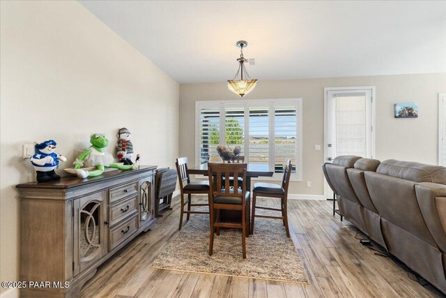 dining space featuring light wood-type flooring and baseboards