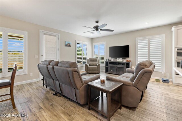 living room featuring ceiling fan, baseboards, light wood-style floors, and recessed lighting