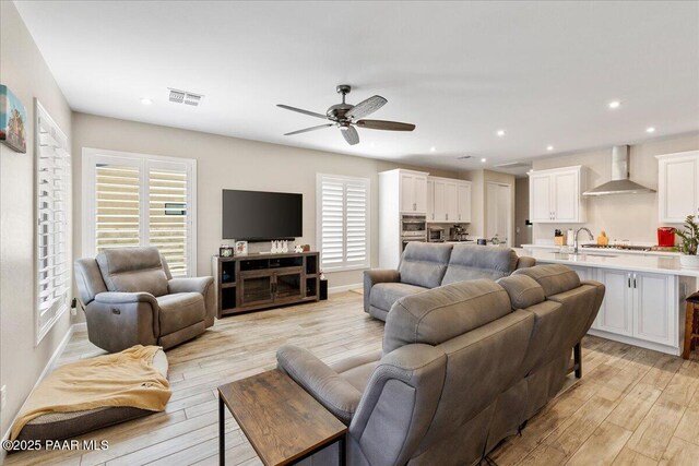 living room with recessed lighting, light wood-style flooring, visible vents, and ceiling fan