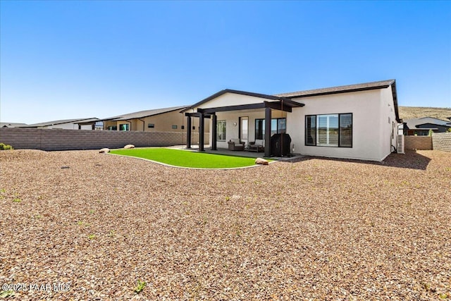rear view of property featuring a patio area, a fenced backyard, and stucco siding