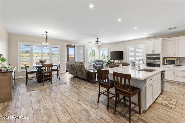kitchen featuring stainless steel appliances, light countertops, visible vents, and white cabinetry