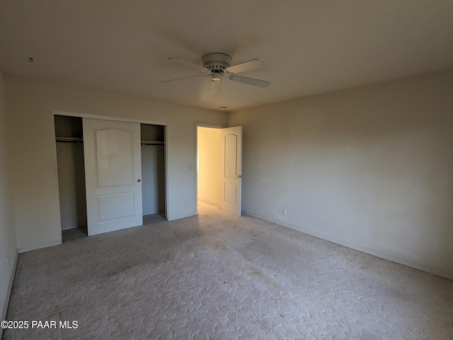 unfurnished bedroom featuring a closet, a ceiling fan, baseboards, and light colored carpet