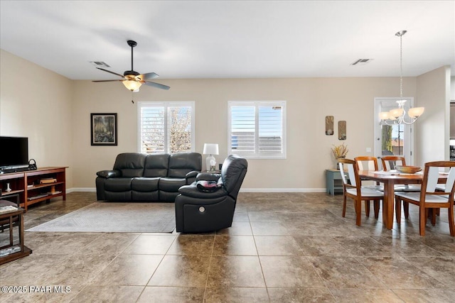 living area with visible vents, ceiling fan with notable chandelier, and baseboards