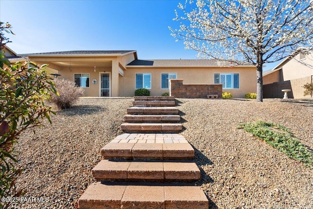 rear view of house with stucco siding