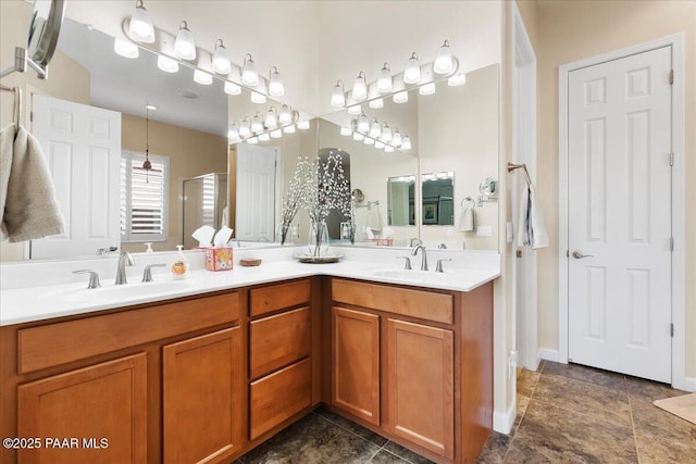full bath with a sink, a shower with door, and double vanity