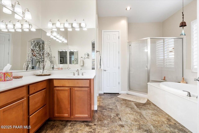 full bathroom with double vanity, a shower stall, a garden tub, and a sink