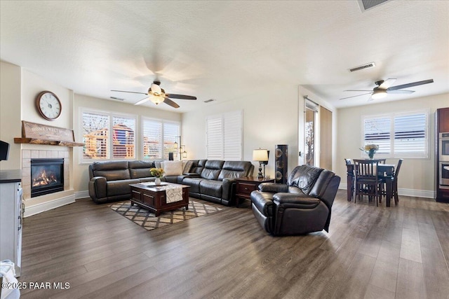 6969 E Encampment Dr, Prescott Valley, AZ 86314 - living room featuring plenty of natural light, dark hardwood / wood-style floors, a tiled fireplace, and a textured ceiling