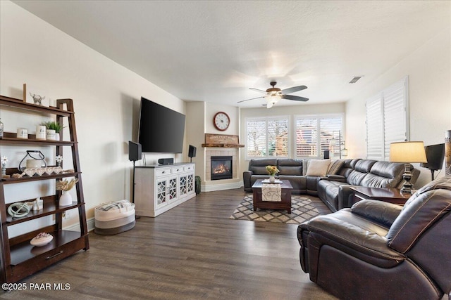 6969 E Encampment Dr, Prescott Valley, AZ 86314 - living room featuring dark wood-type flooring, ceiling fan, a tile fireplace, and a textured ceiling