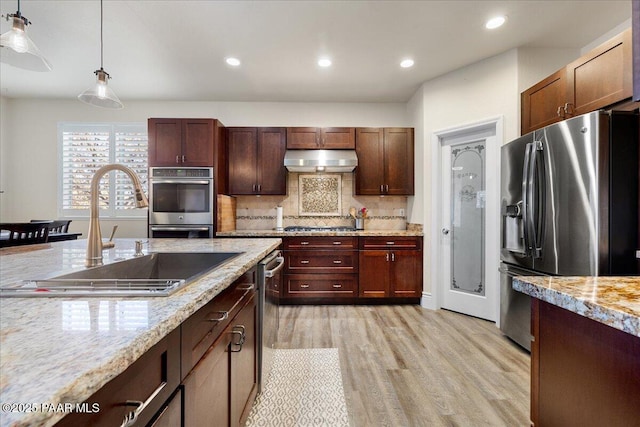 6969 E Encampment Dr, Prescott Valley, AZ 86314 - kitchen with light stone counters, sink, hanging light fixtures, and appliances with stainless steel finishes