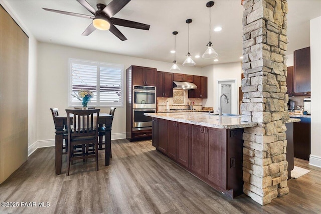 6969 E Encampment Dr, Prescott Valley, AZ 86314 - kitchen featuring sink, light stone counters, pendant lighting, stainless steel appliances, and decorative columns