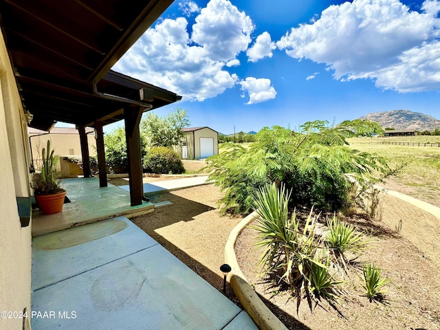 view of patio / terrace with a mountain view and a storage unit