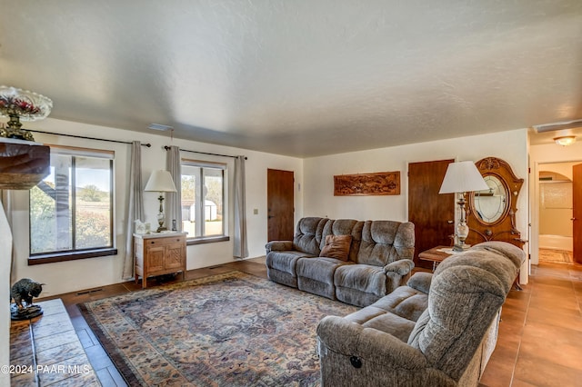 living room with tile patterned flooring and a textured ceiling