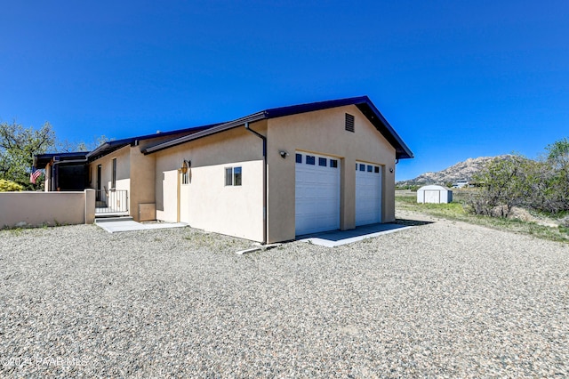 exterior space featuring a mountain view, a storage unit, and a garage