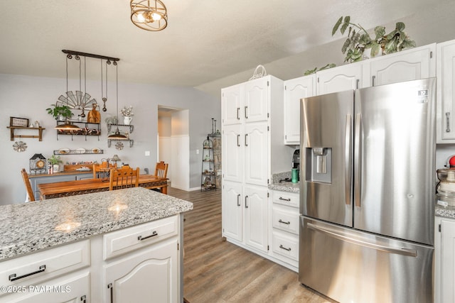 11755 Hondo Hts, Dewey-Humboldt, AZ 86327 - kitchen featuring stainless steel refrigerator with ice dispenser, light wood finished floors, white cabinetry, light stone counters, and lofted ceiling