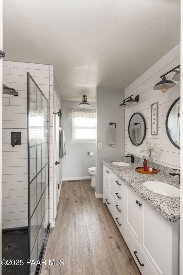 11755 Hondo Hts, Dewey-Humboldt, AZ 86327 - bathroom featuring a shower stall, double vanity, wood finished floors, toilet, and baseboards
