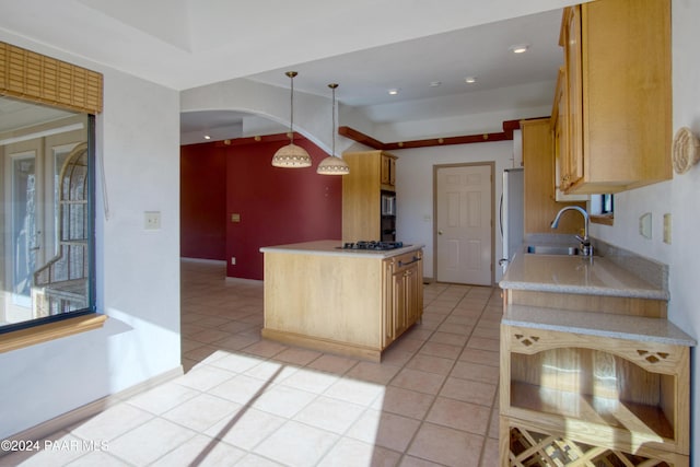 kitchen with light brown cabinets, light tile patterned flooring, sink, hanging light fixtures, and white fridge