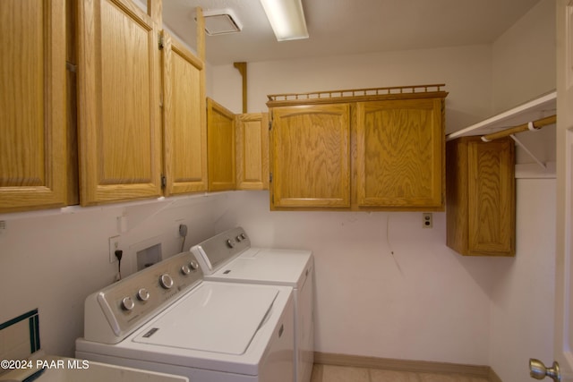 washroom featuring cabinets and washer and clothes dryer