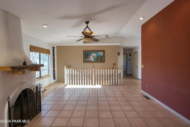 unfurnished living room featuring ceiling fan, light tile patterned floors, and vaulted ceiling