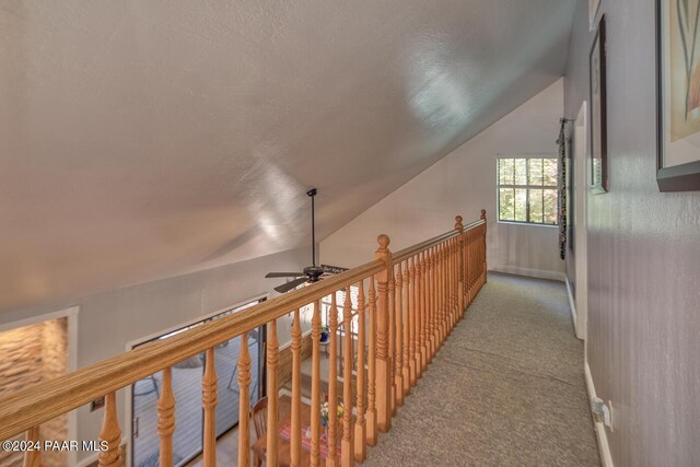 hall with light carpet and vaulted ceiling