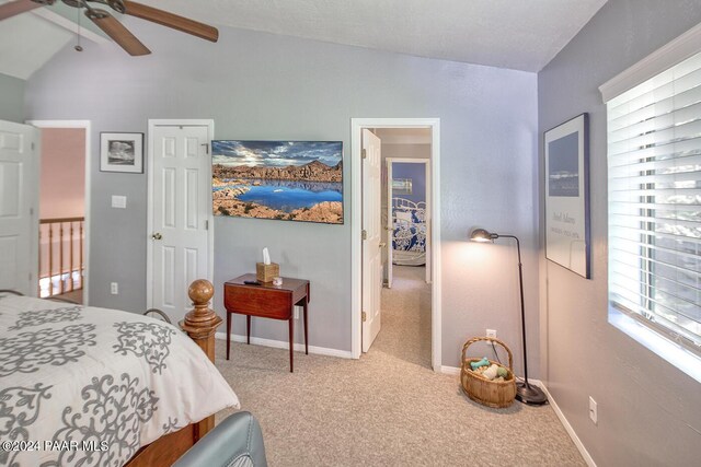 bedroom with ceiling fan, carpet floors, and vaulted ceiling