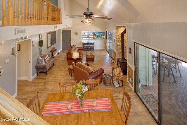 dining room featuring wood-type flooring, high vaulted ceiling, and ceiling fan