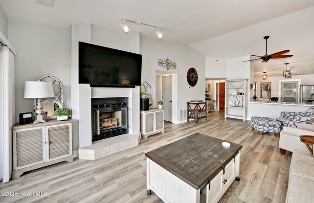 2151 S Resort Way Unit 1C, Prescott, AZ 86301 - living room featuring a fireplace, a ceiling fan, visible vents, lofted ceiling, and light wood finished floors
