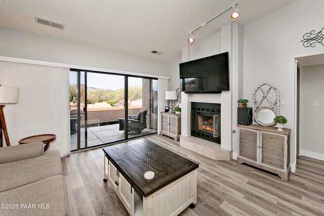 2151 S Resort Way Unit 1C, Prescott, AZ 86301 - living area with visible vents, vaulted ceiling, light wood-style floors, and a fireplace