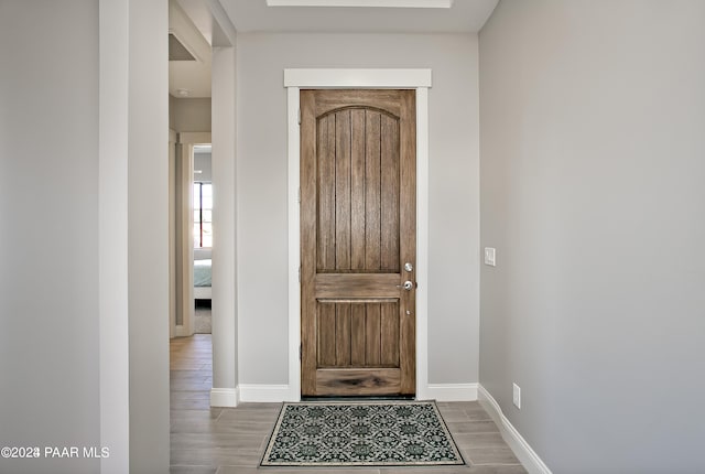 foyer entrance with baseboards and wood finished floors