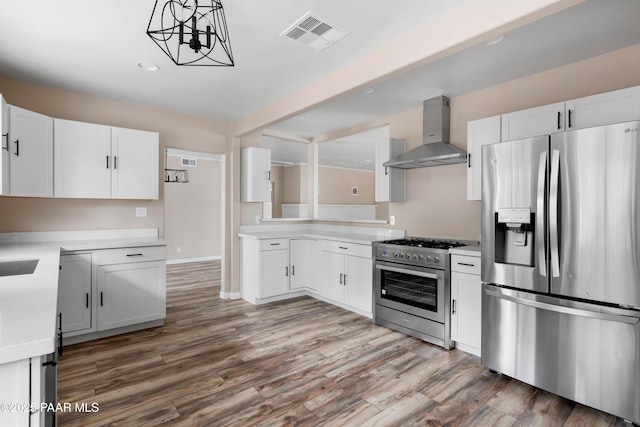 315 N Robinson Dr, Prescott, AZ 86303 - kitchen with appliances with stainless steel finishes, wall chimney range hood, light countertops, wood finished floors, and white cabinets