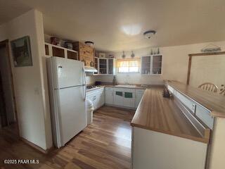 16432 Incline Trl, Williams, AZ 86046 - kitchen featuring freestanding refrigerator, wood finished floors, exhaust hood, white cabinets, and glass insert cabinets
