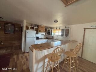 16432 Incline Trl, Williams, AZ 86046 - kitchen featuring freestanding refrigerator, wood finished floors, a peninsula, and a kitchen breakfast bar
