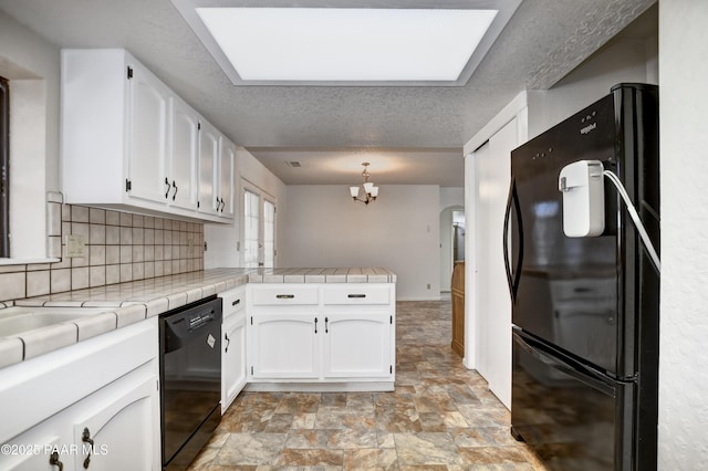 3718 N Navajo Dr, Prescott Valley, AZ 86314 - kitchen with stone finish flooring, black appliances, a peninsula, and white cabinets