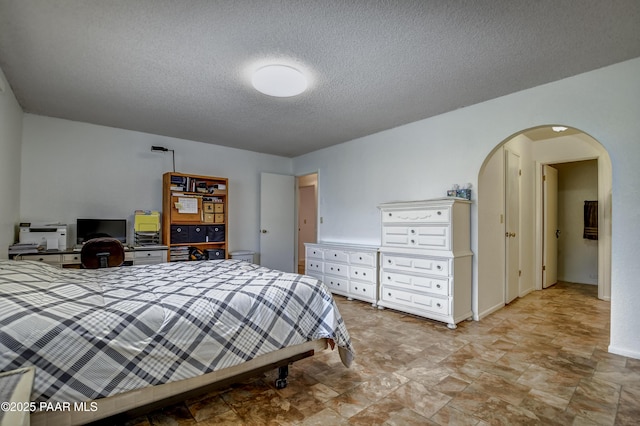 3718 N Navajo Dr, Prescott Valley, AZ 86314 - bedroom featuring stone finish floor, arched walkways, and a textured ceiling