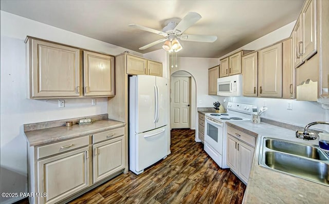 kitchen with arched walkways, ceiling fan, white appliances, dark wood-type flooring, and a sink